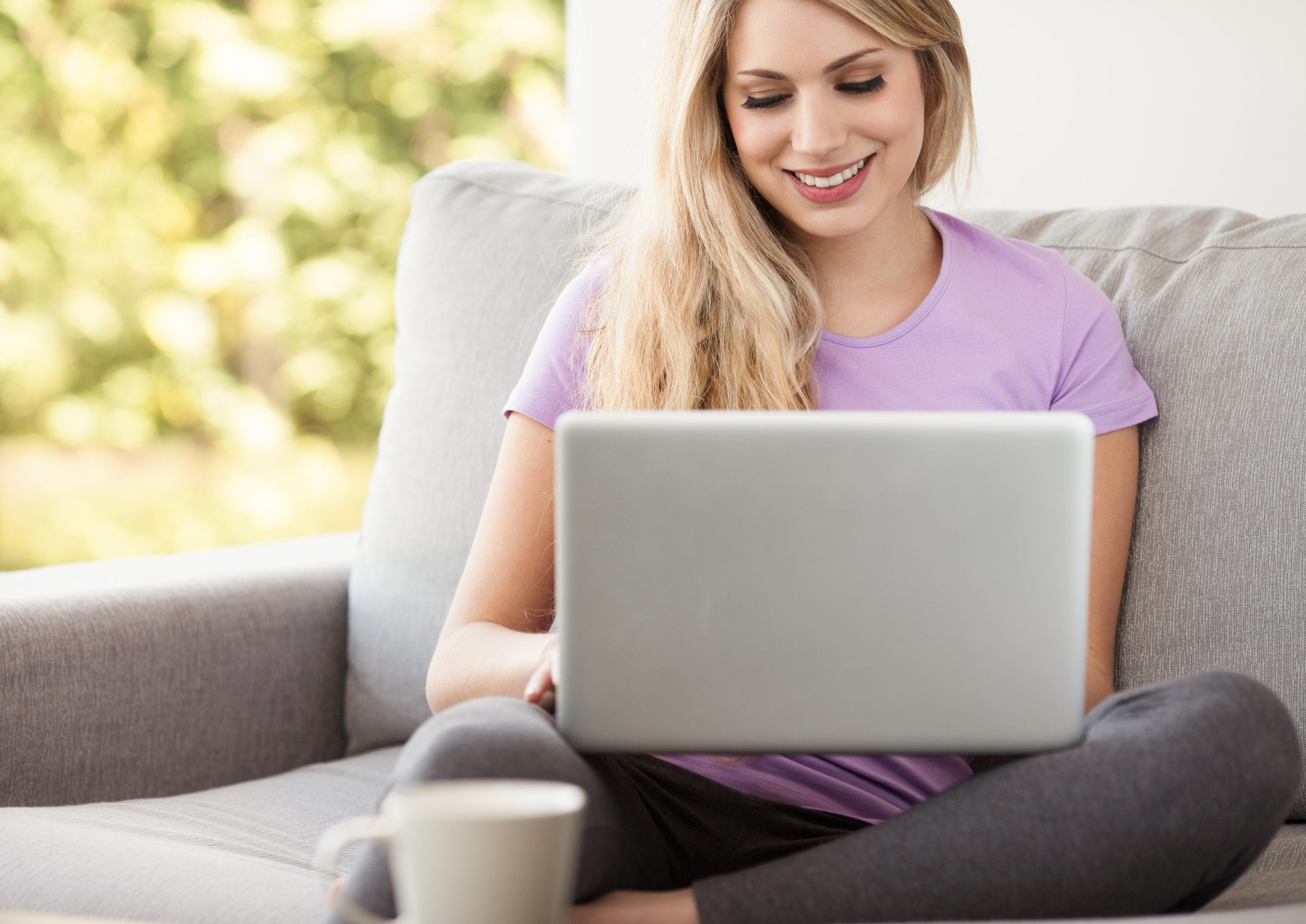 young beautiful woman using a laptop at home Woman using a laptop computer at home representing display advertising and remarketing