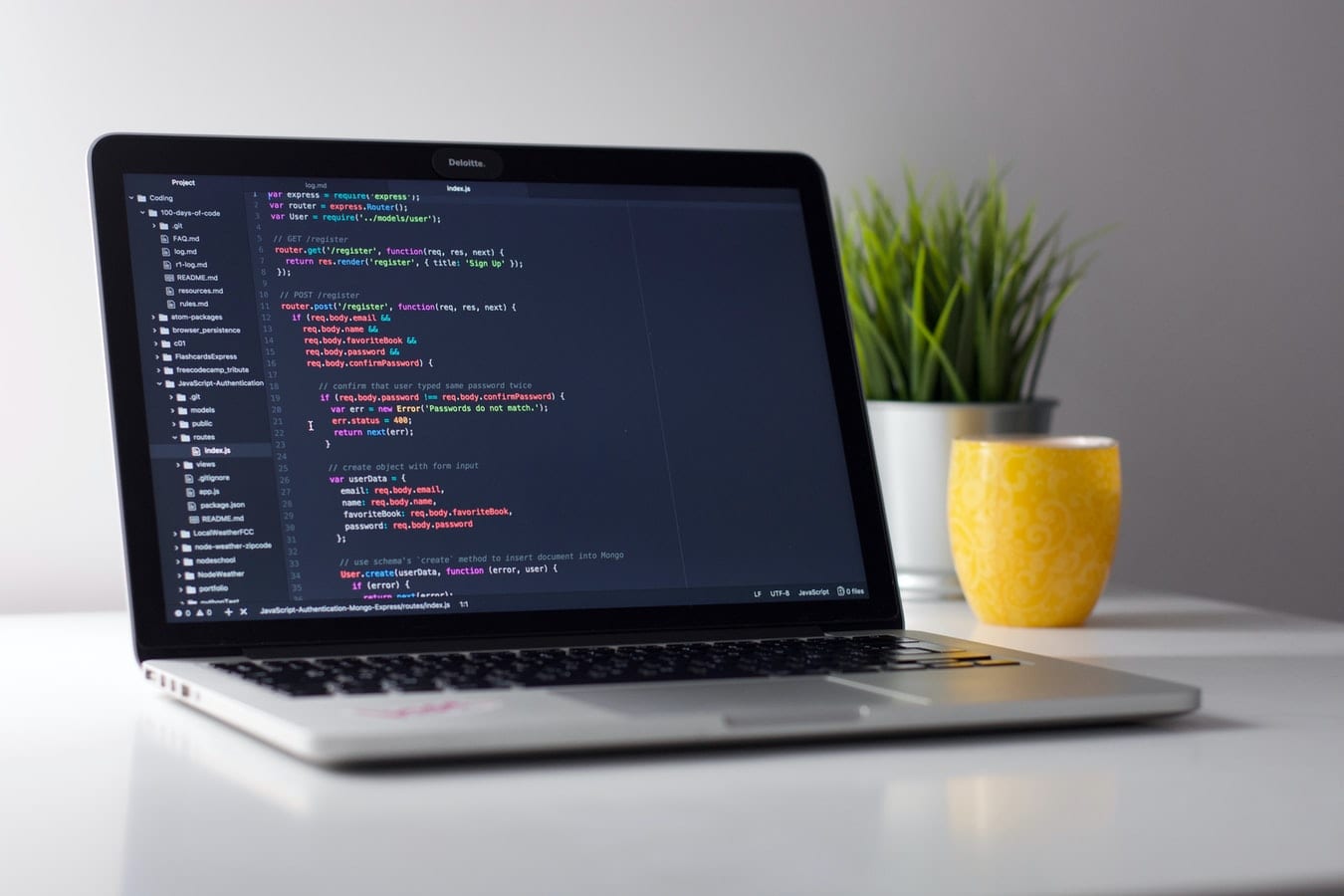 Laptop sitting on a table with code on the screen representing webmaster services.