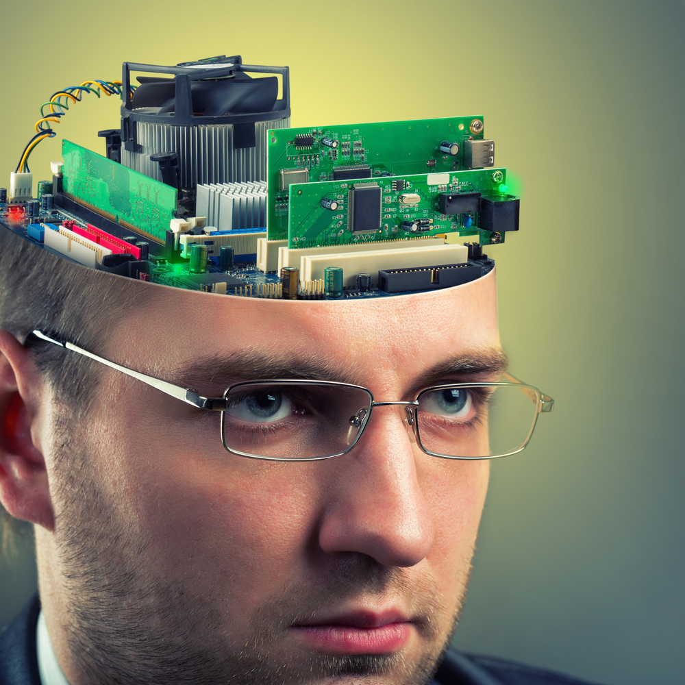 Confident businessman with computer in head representing how closely humans and machines work together.
