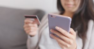 Woman shops with her mobile phone. Google's Ads is incorporating its Shoppable Ads into Google Images search results for increased traffic and lower cpc.