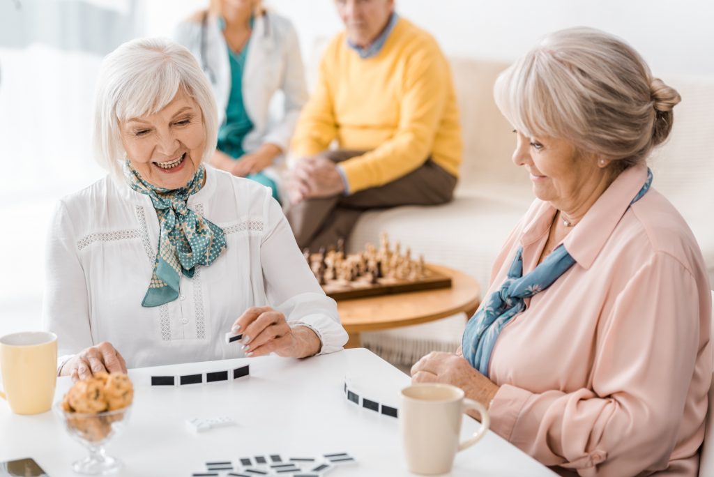 Seniors enjoying tea and dominos in a luxury senior living coommunity