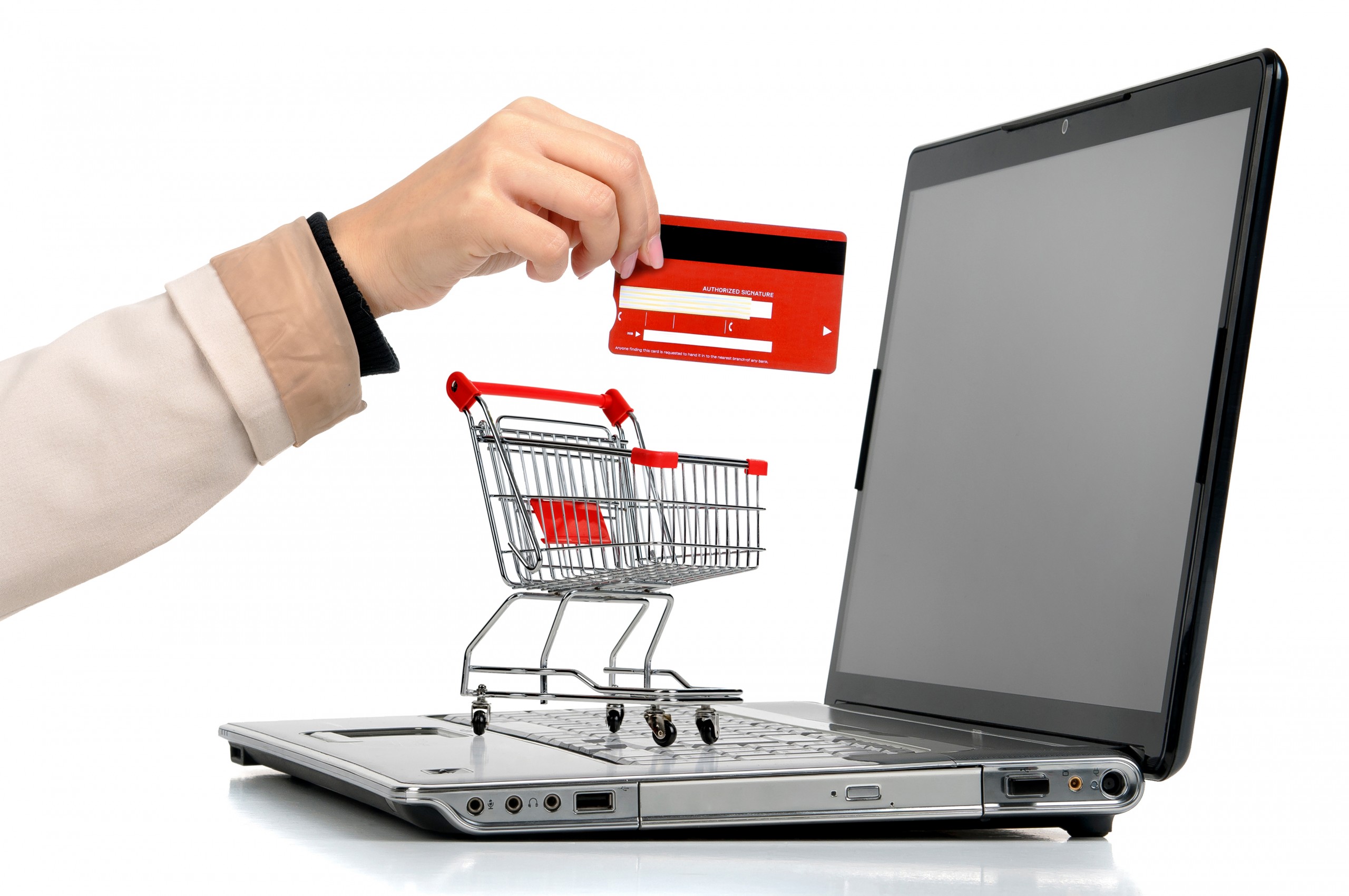 Laptop with small shopping cart and a hand with credit card symbolizing online shopping.