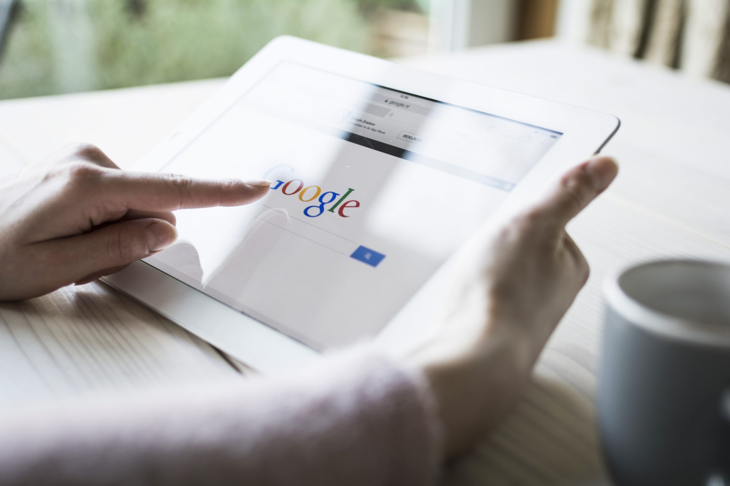 Depositphotos_39915863_xl-2015 Someone browsing Google on an ipad at home.