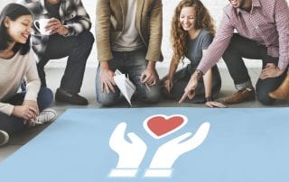 Diverse group of people surrounding a poster with hands and a heart symbolizing nonprofit digital marketing.