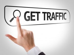A person's finger pointing at a search bar that says "GET TRAFFIC"