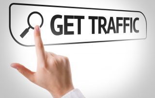 A person's finger pointing at a search bar that says "GET TRAFFIC"