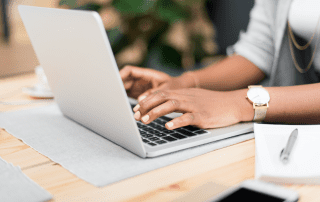 close up of person's hands typing on a laptop