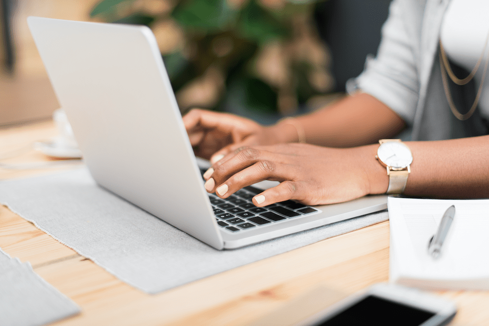 close up of person's hands typing on a laptop