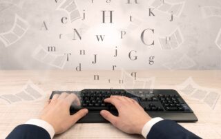 business person's hands on a keyboard while documents and letters fly around, illustrating content scaling and how to scale content creation